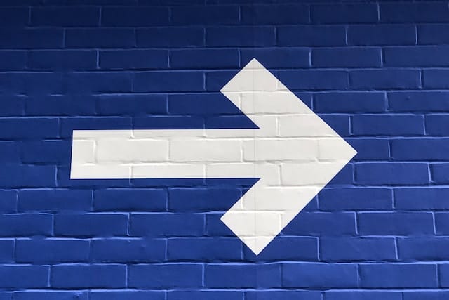 Signo blanco de flecha indicando a la derecha en un fondo azul