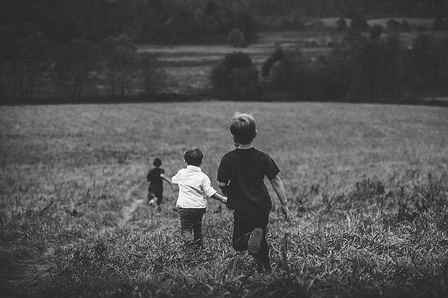 Menores jugando en un predio. Foto en blanco y negro.